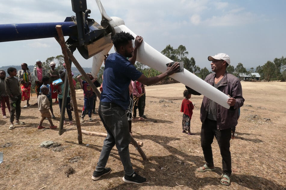 Frischer Anstrich nach der Wartung: Dorfbewohner und Hahns Fahrer (l.) schleifen Anfang des Jahres die Rotorblätter ab, bevor sie neu lackiert werden.
