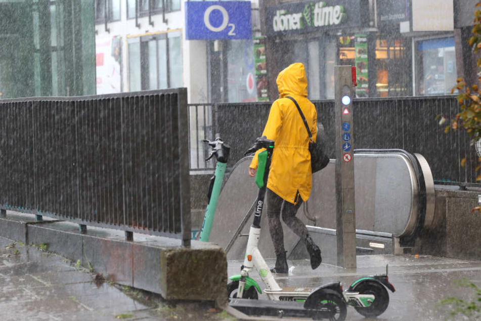 Bei starkem Regen geht eine Frau in Hamburg in eine Unterführung.