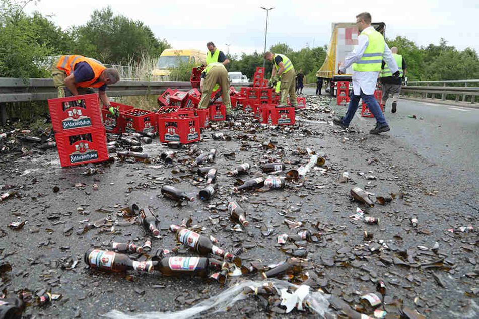 Mehrere Helfer befreien die Straße von dem Bier.