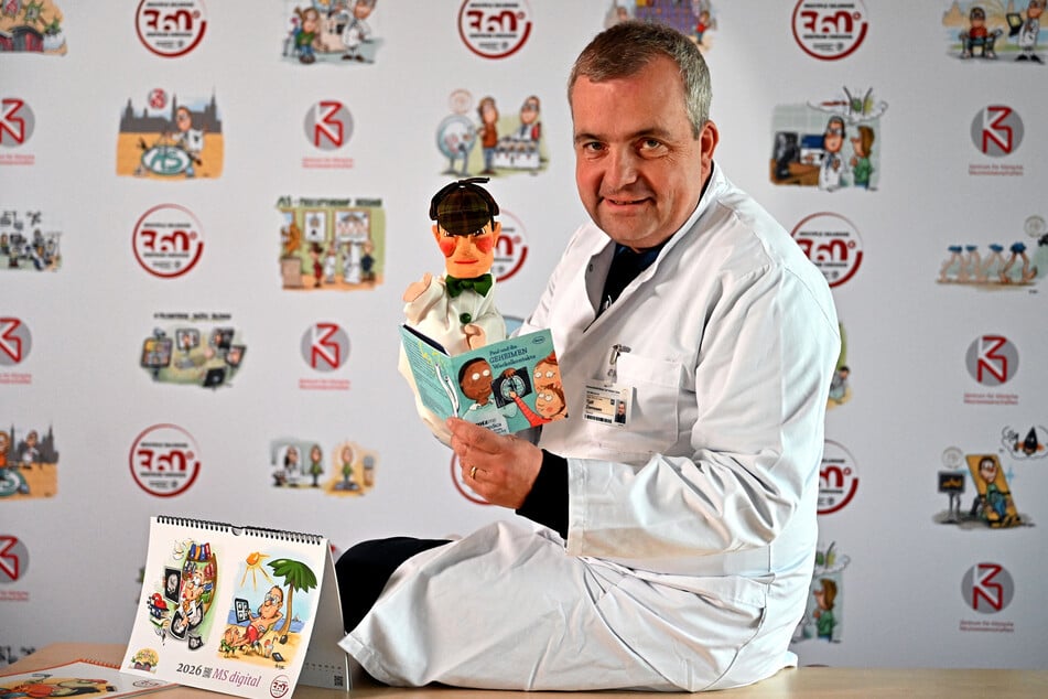 Tjalf Ziemssen (52) mit der Puppe "Sherlock MS" und dem Kinderbuch.