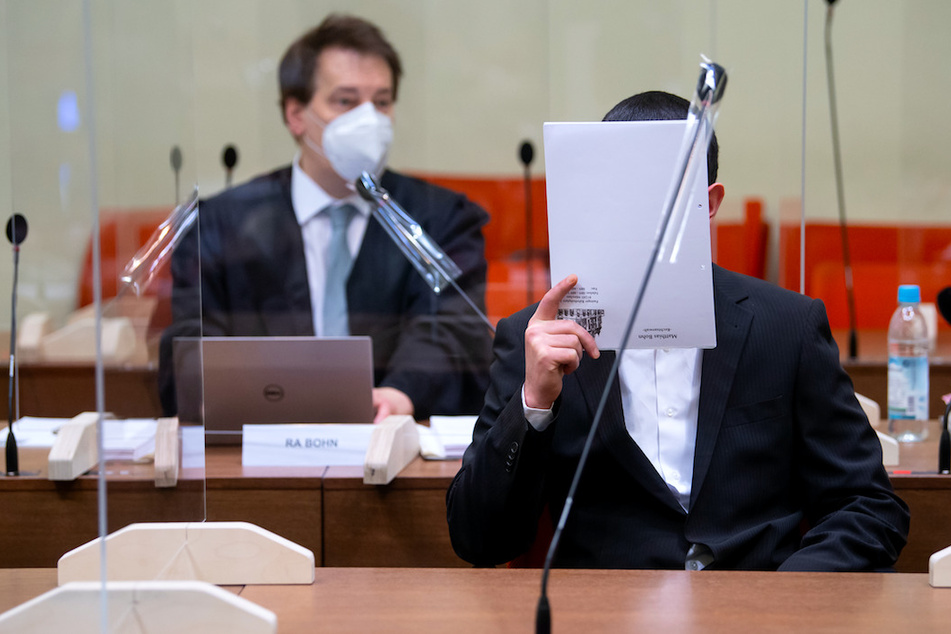 Der wegen versuchten Mordes in 31 Fällen, schwerer Brandstiftung und Vorbereitung einer schweren staatsgefährdenden Gewalttat angeklagte Mann (r.) sitzt vor Prozessbeginn mit seinem Anwalt Matthias Bohn im Landgericht im Verhandlungssaal.