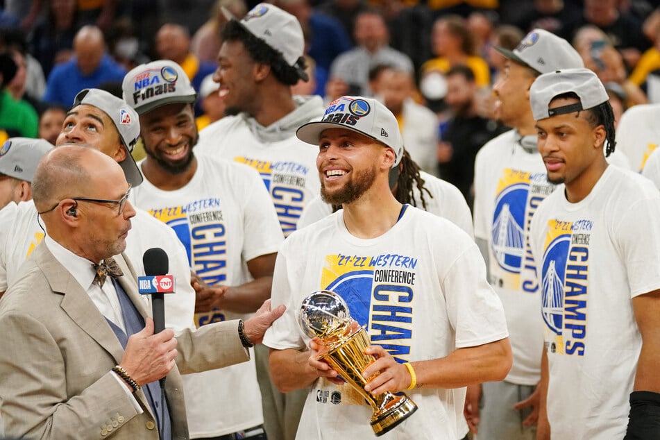 Steph Curry (c.) with the Western Conference Finals MVP trophy.