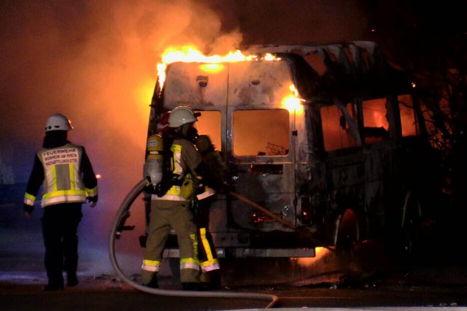 Feuerwehrleute versuchen das brennende Wohnmobil zu löschen.