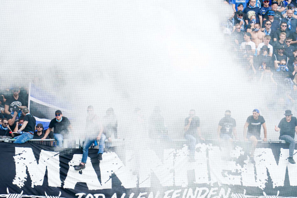Hinspiel: Fans vom SV Waldhof stehen im Rauch auf der Gästetribüne des Fritz-Walter-Stadions in Kaiserslautern.