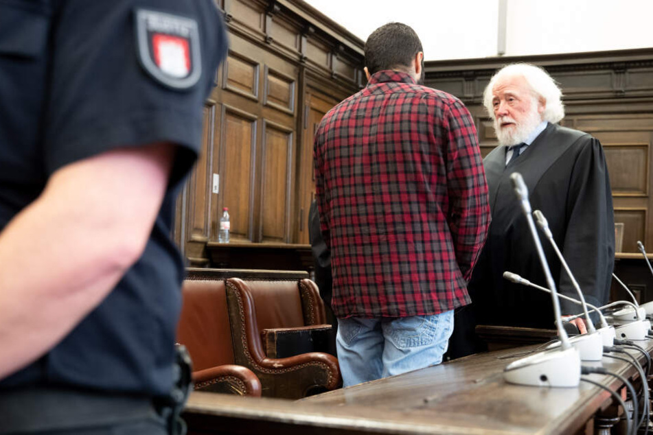 Der Angeklagte unterhält sich mit seinem Anwalt im Gerichtssaal.