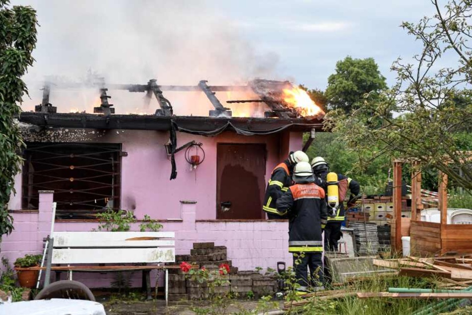 Die Einsatzkräfte der Feuerwehr löschen einen der Lauben-Brände in Wilhelmsburg.
