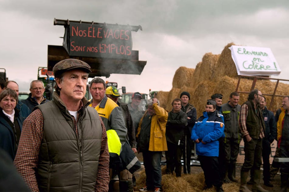 Bürgermeister Georges Balbuzard (Francois Cluzet; links) blockiert mit den Bauern seines Dorfes die Autobahn, um Aufmerksamkeit zu erregen.