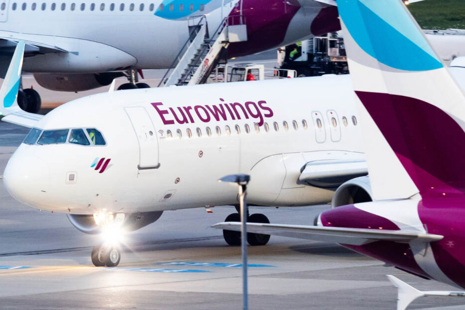Ein Flugzeug der Fluggesellschaft Eurowings rollt am Düsseldorfer Flughafen über das Vorfeld an parkenden Flugzeugen vorbei.