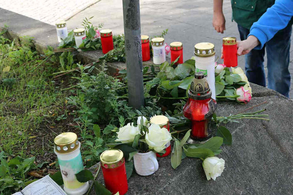 Menschen stellen Kerzen am Tatort in der Friedrichstraße auf.