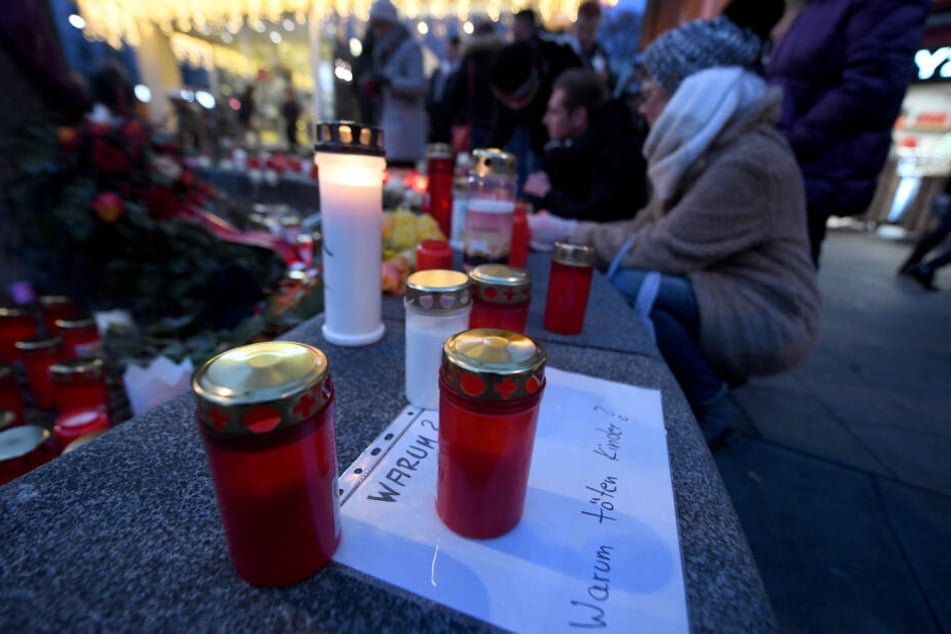 Ein Grablicht steht auf einem Zettel "Warum? Warum töten Kinder?" am Königsplatz.