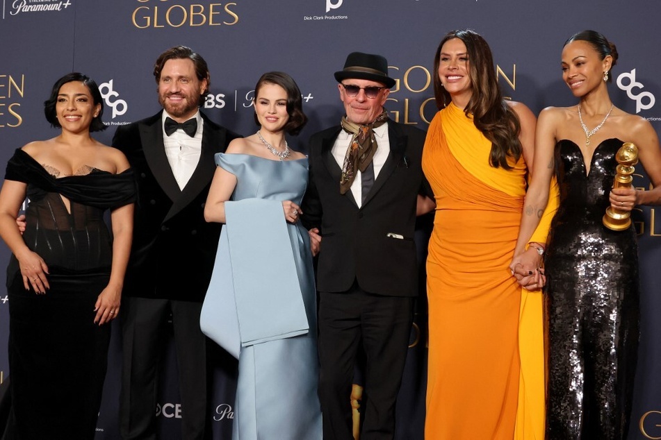 From l. to r.: Adriana Paz, Edgar Ramírez, Selena Gomez, Jacques Audiard, Karla Sofía Gascón, and Zoe Saldana of Emilia Perez pose in the press room during the 82nd Annual Golden Globe Awards on January 5, 2025.