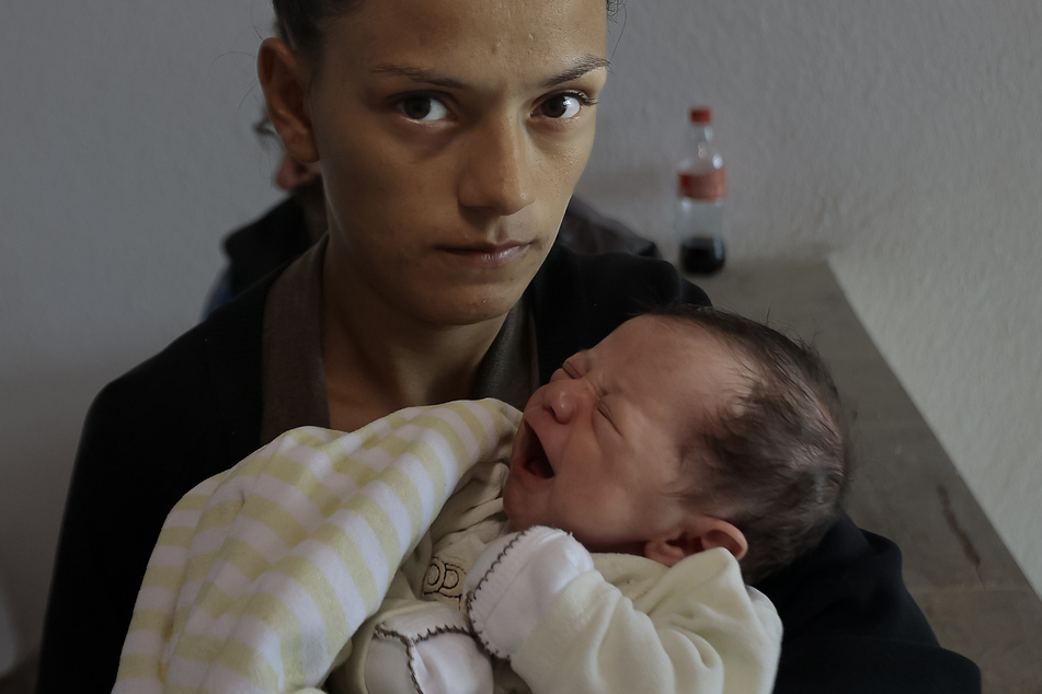 Eine armenische Frau und ihr Neugeborenes warten in einem Lager auf Hilfe.