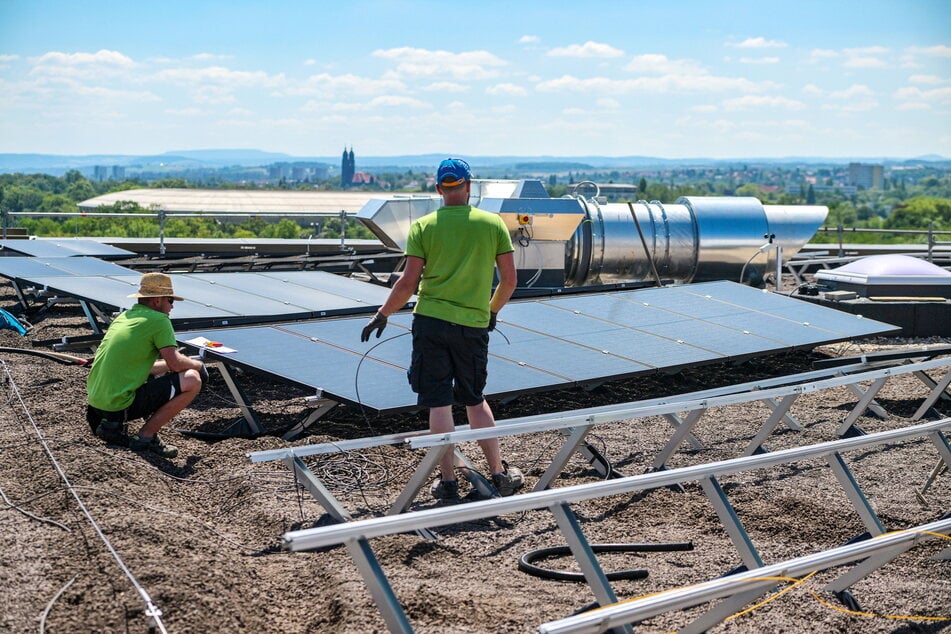 Arbeiter montieren in den kommenden Tagen insgesamt 376 Solar-Module auf dem Dach.