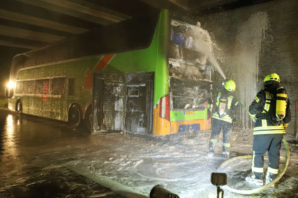 Feuerwehrmänner löschen den Brand am Flixbus.