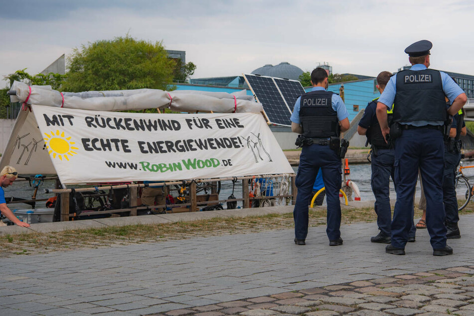 Polizeibeamte stehen im Regierungsviertel von Berlin an einem Floß der Umweltschutzorganisation Robin Wood. Die Aktivisten fordern mit ihrer dreiwöchigen Floßtour eine "echte" Energiewende.