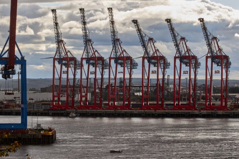 Die Kräne am Hafen hängen in einer Wolkendecke.