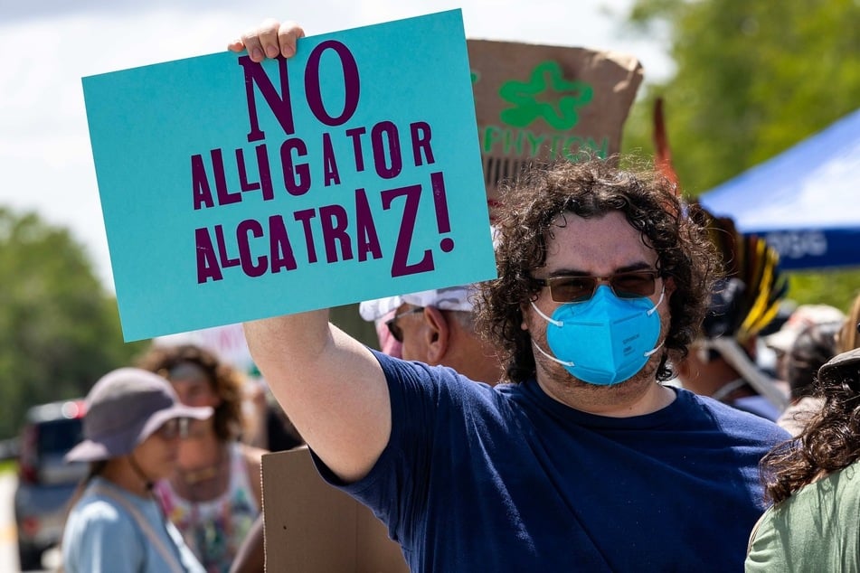 A protester holds a sign reading "No Alligator Alcatraz!" during a rally against the proposed construction of a massive immigrant detention center in the Florida Everglades.