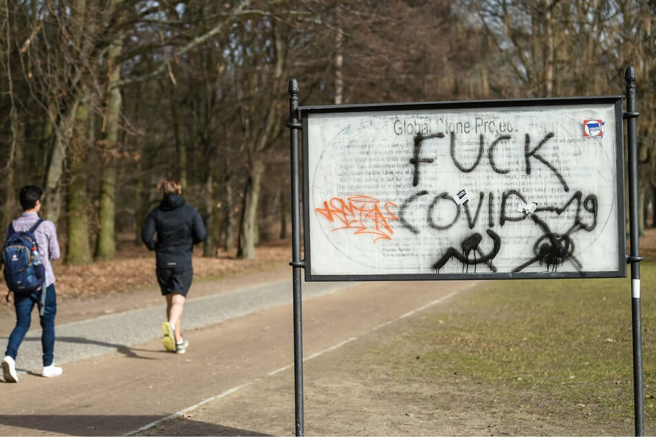 Auf einem Schild im Tiergarten ist "Fuck Covid-19" gesprüht.