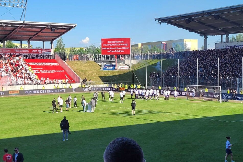 Aue-Chaoten schmeißen Pyrotechnik in Richtung der Zwickauer Fans.