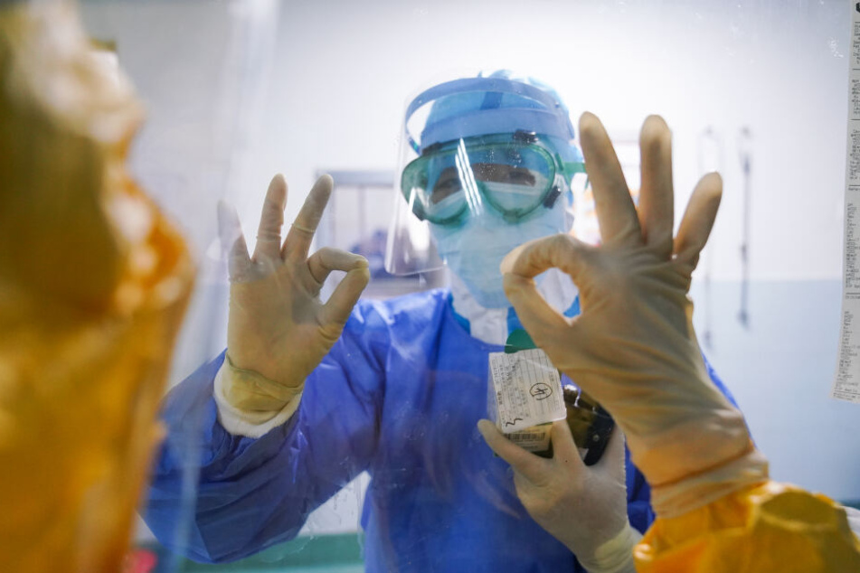 Zhangzhou: Mediziner gestikulieren durch das Fenster im Zhangzhou Municipal Hospital, in der südostchinesischen Provinz Fujian.