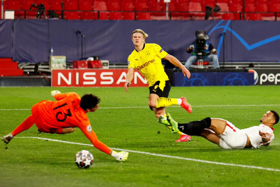 Der krönende Abschluss einer fantastischen ersten BVB-Hälfte: Erling Haaland (M.) überwindet Sevilla-Keeper Bono (l.) mit diesem Flachschuss in die linke Ecke zum 3:1 für Dortmund.