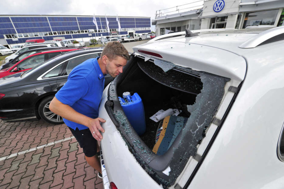 Autohaus-Mitarbeiter Tassilo Herzig (36) schaut durch die von der abgeschmierten Drohne zertrümmerte Heckscheibe des Kundenwagens.