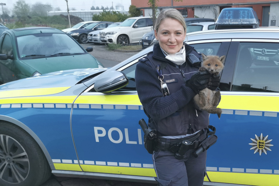 Eine Polizeibeamtin hält den Fuchs auf dem Arm.