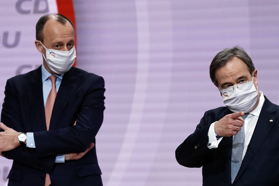 Der neue Parteivorsitzende Armin Laschet (r.) gestikuliert neben Friedrich Merz zum Abschluss des digitalen Bundesparteitags der CDU.