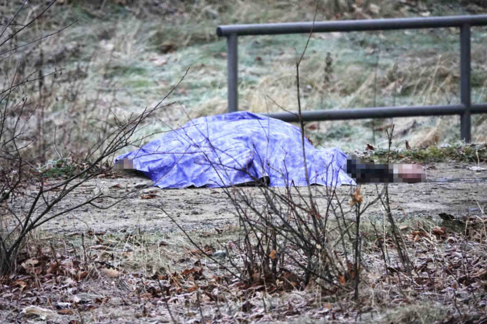 Die Leiche liegt abgedeckt neben dem Bach.