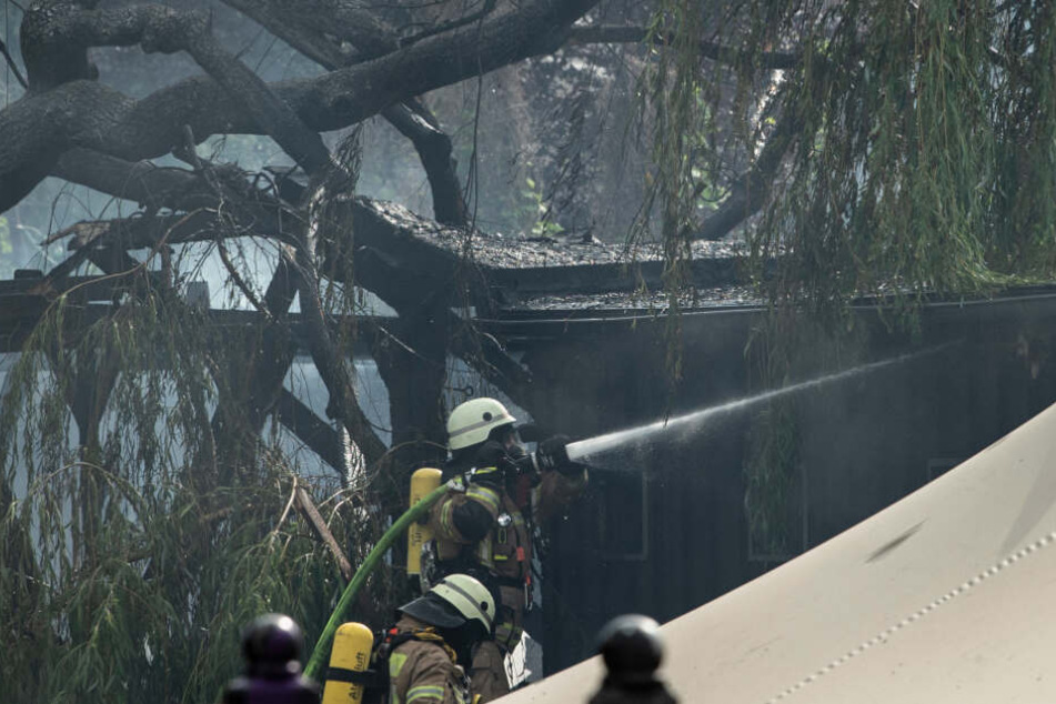 Feuerwehrleute bekämpfen auf einem Grundstück an der Straße Am Flutgraben einen Brand.