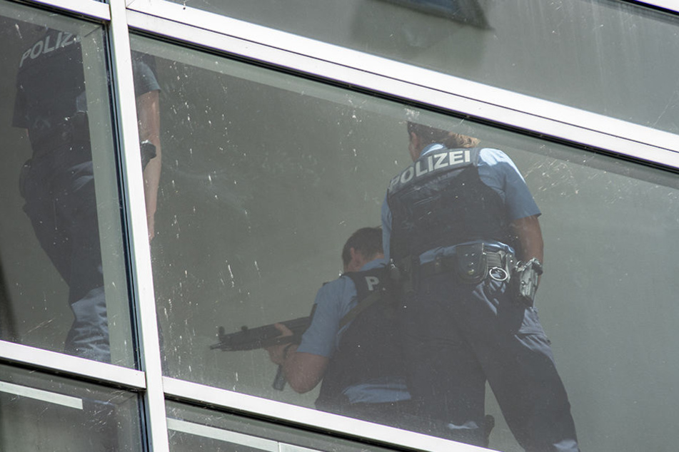 Schwer bewaffnete Polizisten nähern sich der nächsten Parkebene um diese abzusuchen.