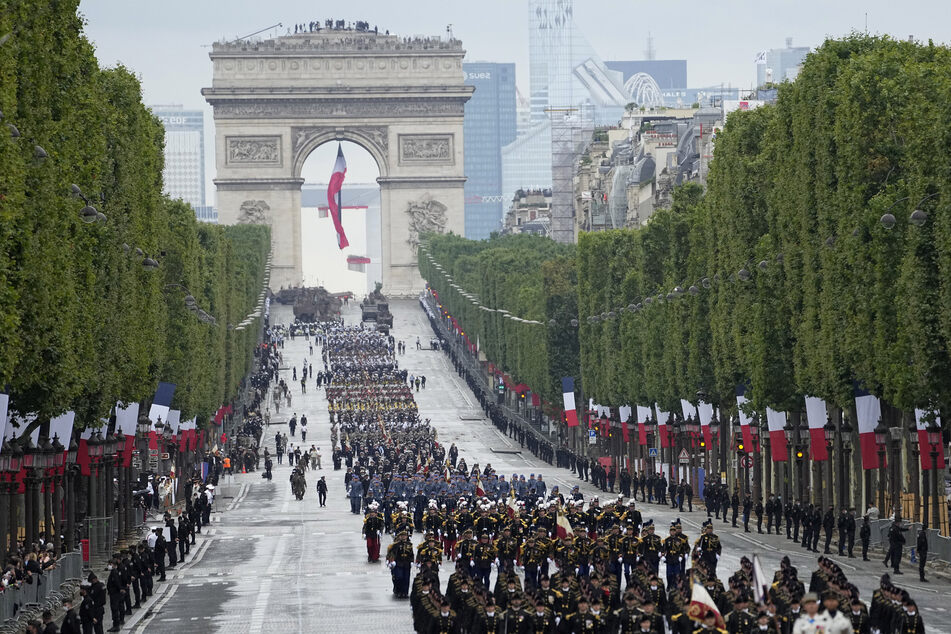 Truppen marschieren in der Militärparade zum Tag der Bastille über die Champs-Elysees.