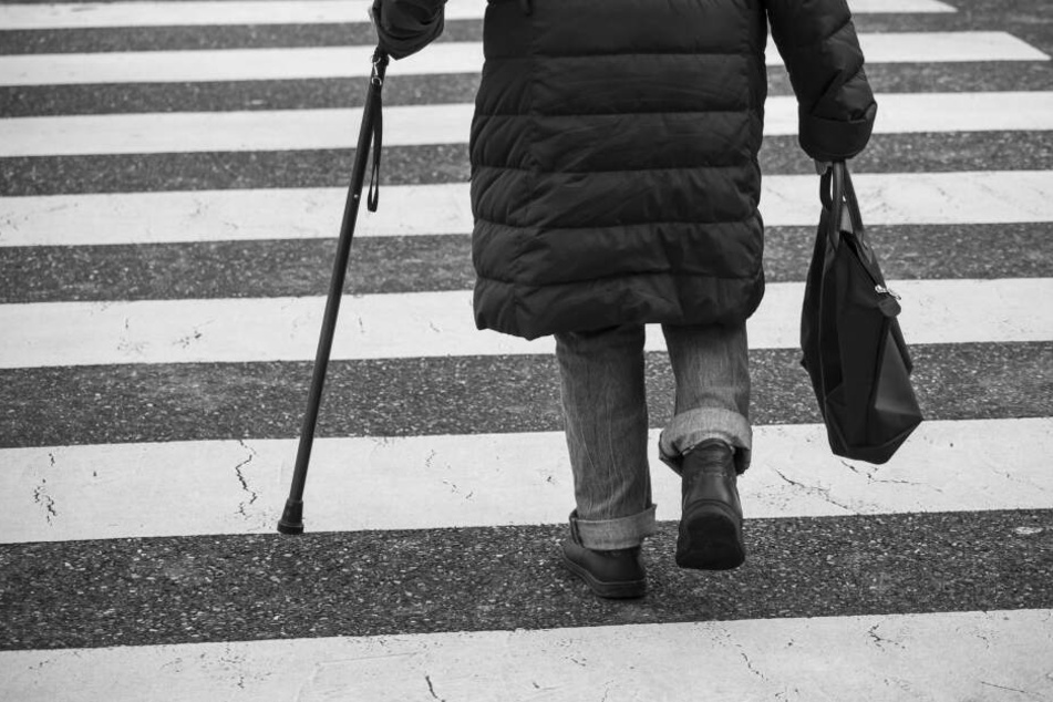 Eine Seniorin überquert eine Straße (Symbolbild).