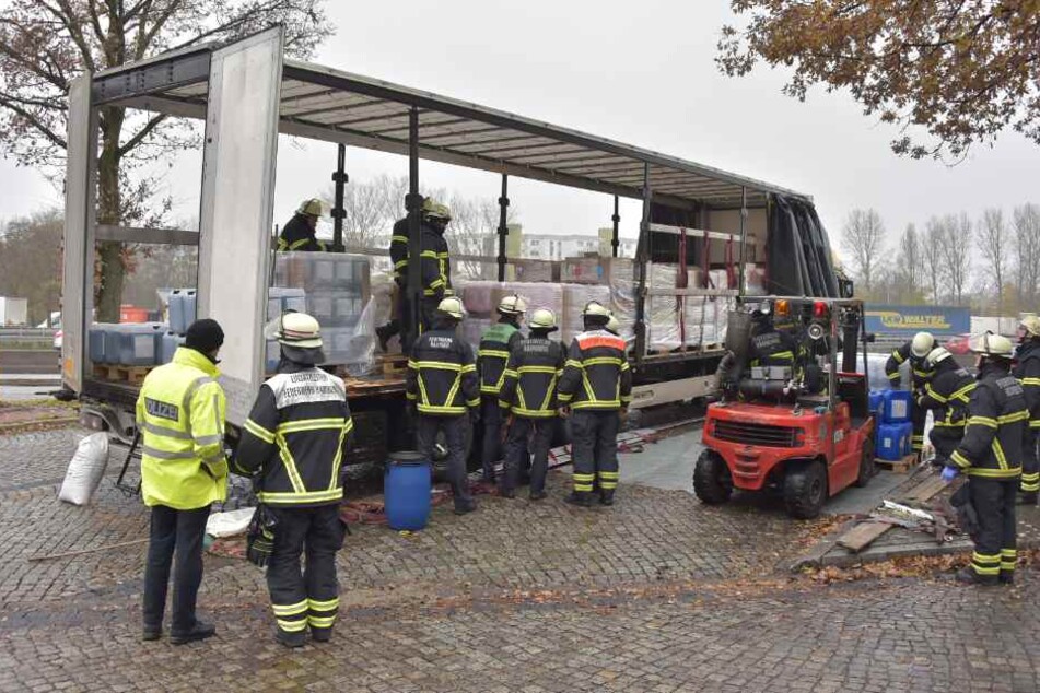 Feuerwehrleute laden den Gefahrgut-Laster ab.