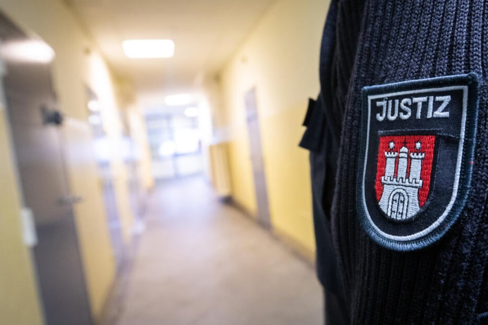 Ein Justizbeamter steht in einem Gang einer JVA.