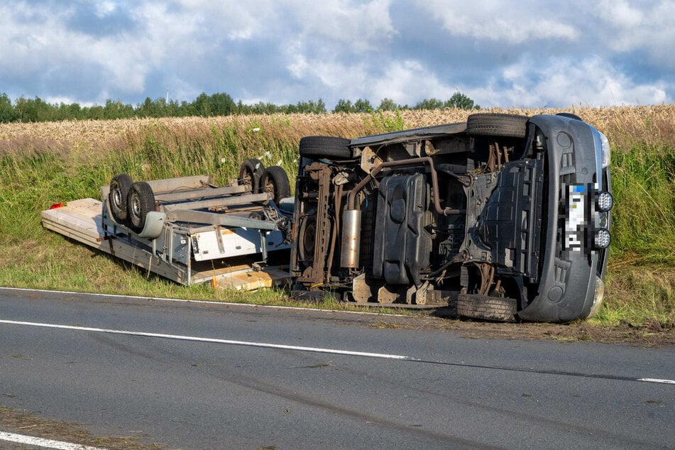 Der Transporter samt Anhänger landete neben der Fahrbahn.