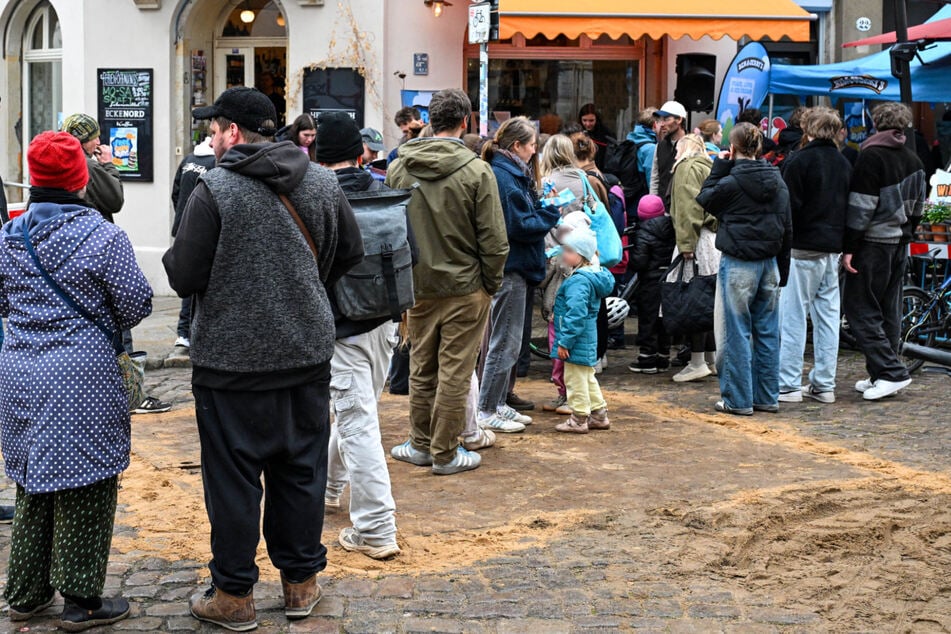 Dresden: Trotz miesen Wetters: Hier "stürmen" Menschen in Dresden eine Truhe mit Gratis-Eis