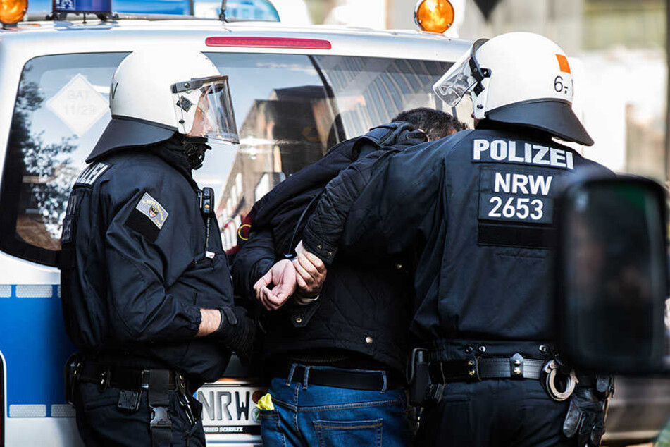 Polizisten führen in Düsseldorf einen randalierenden Demonstranten ab. Bei der Kurden-Demonstration ist es am Samstag zu Zusammenstößen mit der Polizei gekommen.