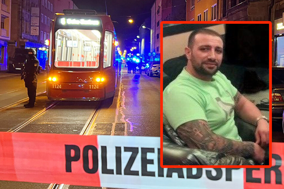 Ein Polizist steht mit einer Maschinenpistole neben dem Tatort in der Nürnberger Südstadt. Seitdem sucht die Polizei nach dem Verdächtigen Mert Fahri A..