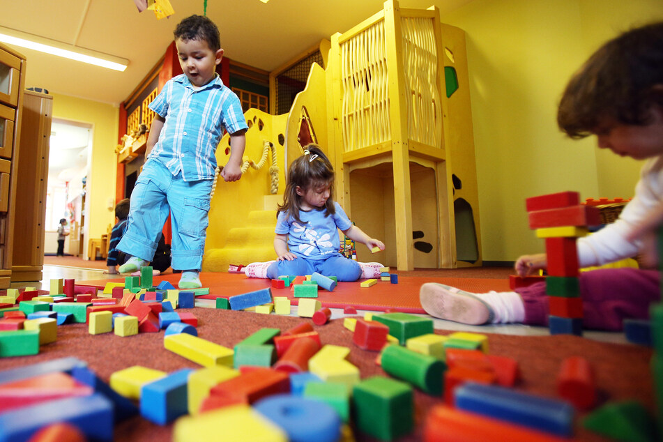 Kinder spielen mit bunten Bauklötzen in einer Kita.