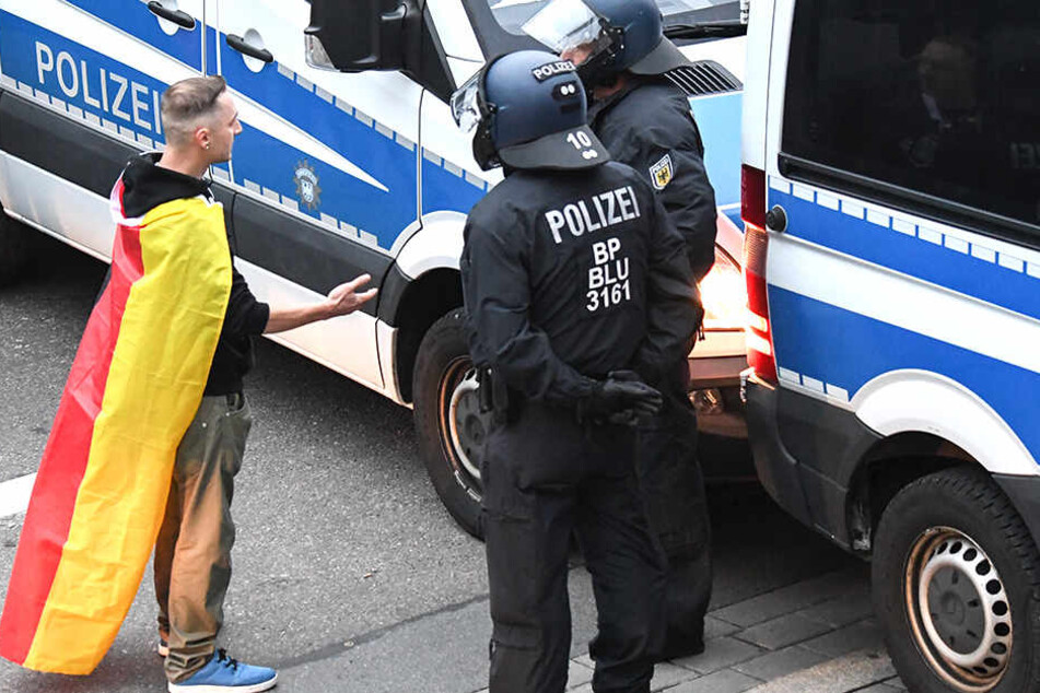 Ein Trauermarsch-Teilnehmer lässt sich auf eine Diskussion mit (den) Polizisten ein.