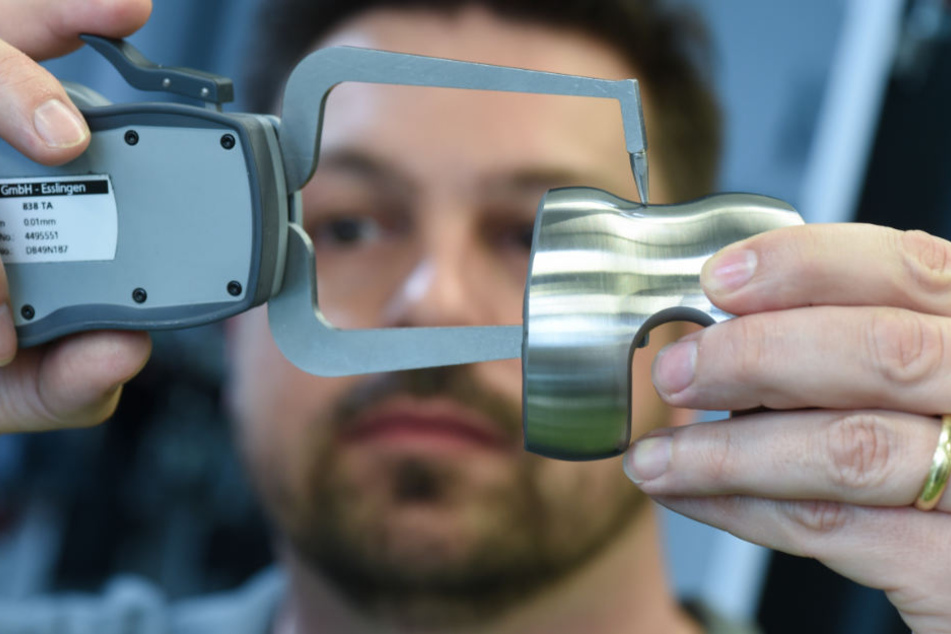Ein Mechaniker prüft ein künstliches Kniegelenk auf seine Stärke.
