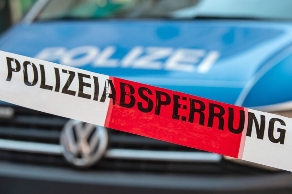 Ein Flatterband mit der Aufschrift "Polizeiabsperrung" ist vor einem Fahrzeug der Polizei zu sehen.(Symbolbild)