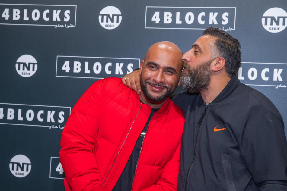 Schauspieler Kida Khodr Ramadan (r.) küsst auf dem Roten Teppich für die Premiere der zweiten Staffel der TNT-Serie "4 Blocks" den Rapper und Schauspieler Veysel Gelin (l.).