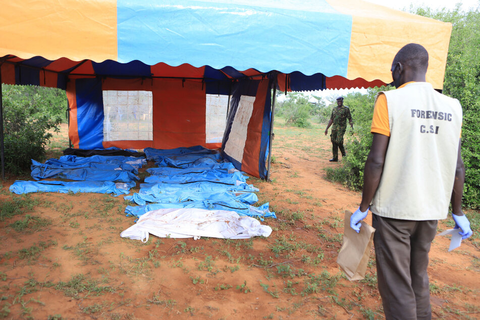 Leichensäcke, in denen sich Todesopfer des christlichen Sektenkultes befinden, liegen während einer Exhumierung in einem Zelt.