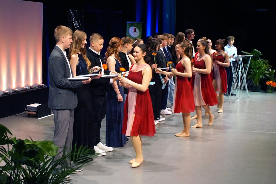 Ein Buch, ein Sinnspruch, eine Gerbera und ein Händedruck: Danach werden die Jugendweihlinge namentlich aufgerufen und vollziehen den symbolischen Schritt in die Welt der Erwachsenen.