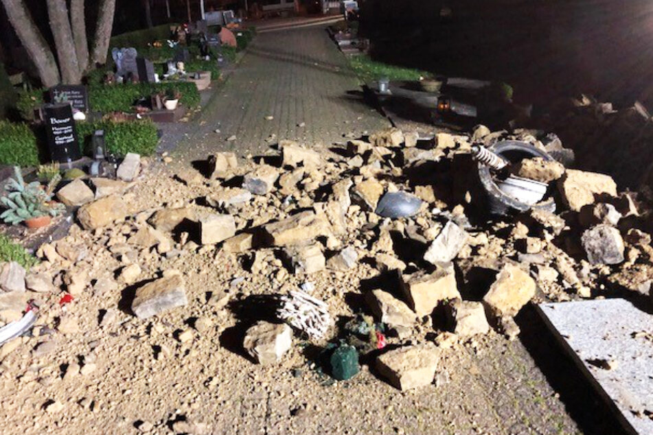 Schwerer Unfall in Bitburg: Trümmerteile einer Mauer fielen in einen Friedhof und beschädigten dort mehrere Gräber.