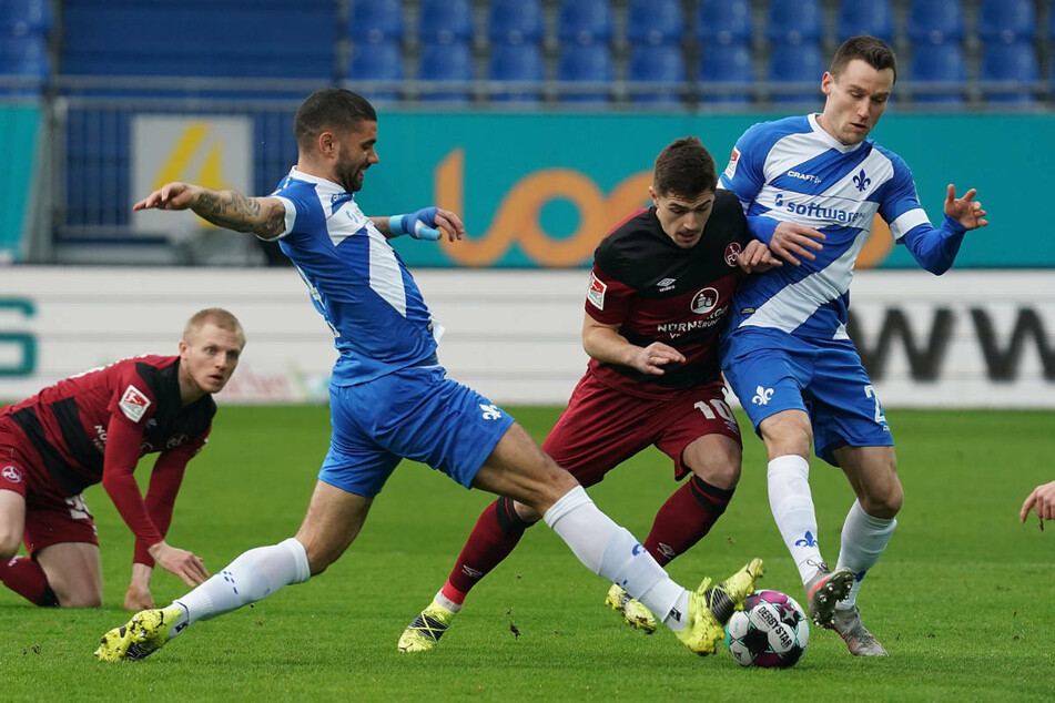 Die Darmstädter Victor Palsson (2.v.l.) und Christian Clemens (r.) im Zweikampf mit Nikola Dovedan aus Nürnberg.