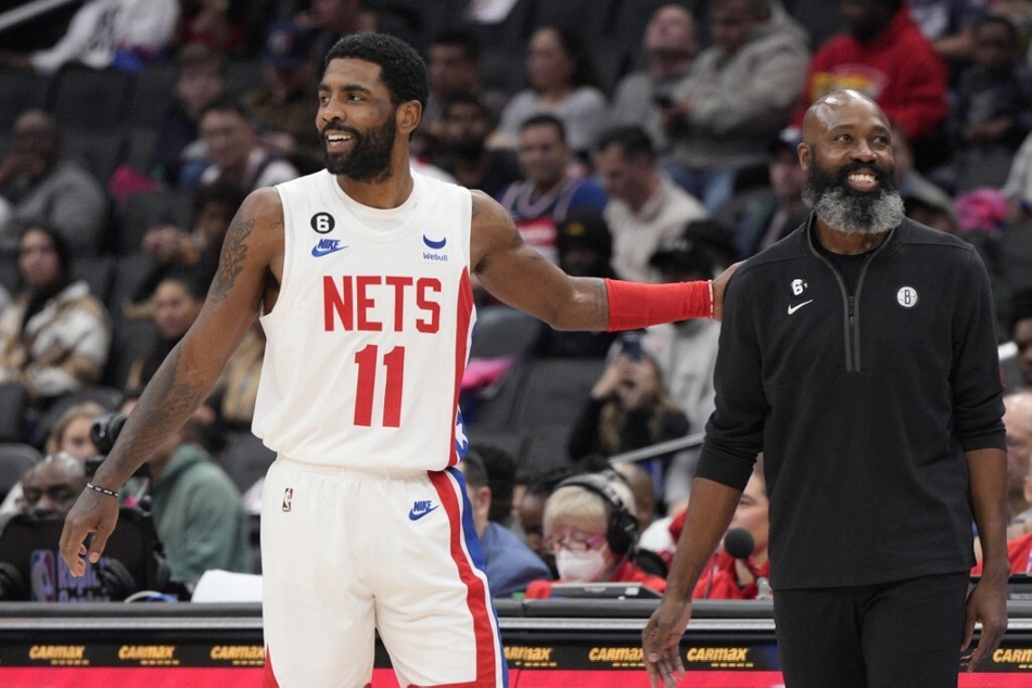 Kyrie Irving of the Brooklyn Nets and head coach Jacque Vaughn talk during a pause in play during a game against the Washington Wizards at Capital One Arena on December 12, 2022.