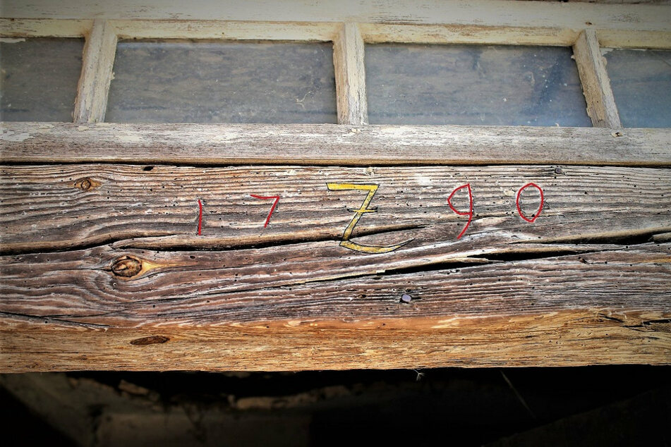 Wie die eingeritzten Ziffern im Türbalken verraten, wurde das alte Fachwerkhaus 1790 umgebaut. Die Sense in der Mitte gilt als Symbol des Scharfrichters.